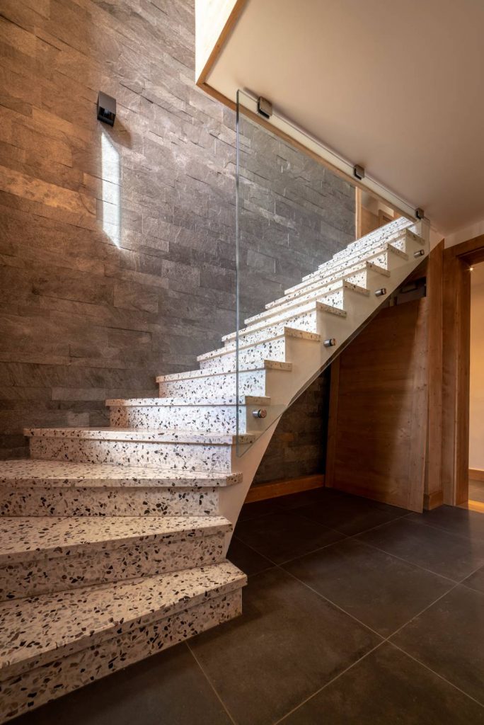 Rénovation sur mesure d'un chalet bois. Escalier en Terrazzo intégré dans une rénovation moderne avec bois et ardoise.