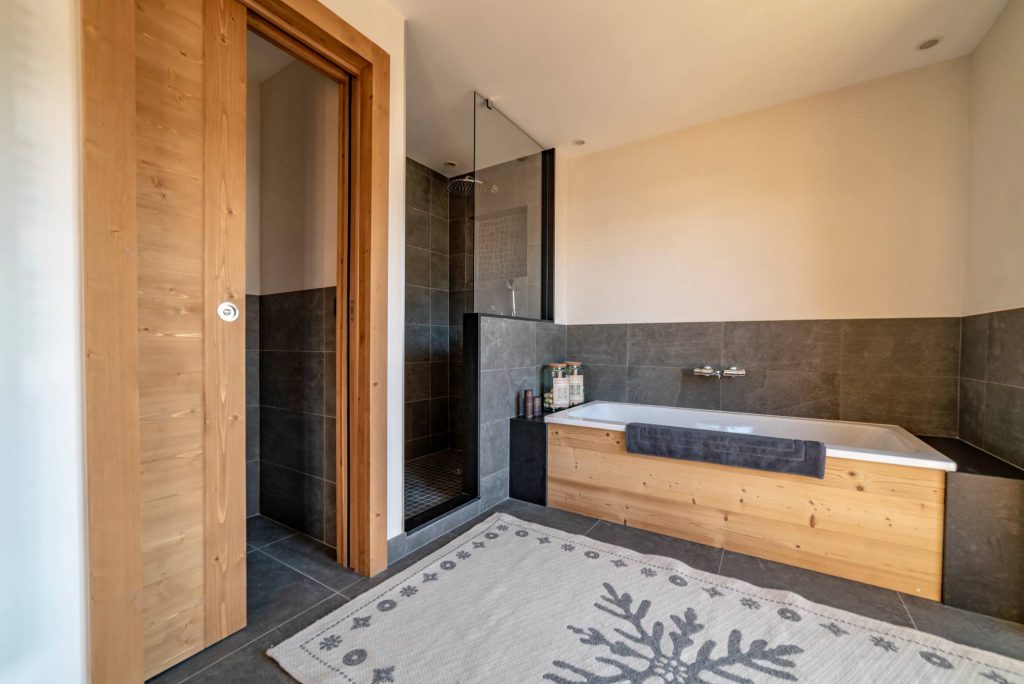 Rénovation et agrandissement d'une salle de bain en bois avec sol en ardoise, dans un chalet.